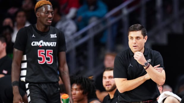 Cincinnati Bearcats head coach Wes Miller paces the sideline as Cincinnati Bearcats forward Aziz Bandaogo (55) finds a seat on the bench in the first half during an NCAA college basketball game between Georgia Tech Yellow Jackets and the Cincinnati Bearcats, Wednesday, Nov. 22, 2023, at Fifth Third Arena in Cincinnati.
